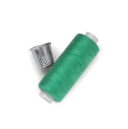 Photo of Thimble and spool of green sewing thread isolated on white, top view