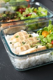 Photo of Healthy food. Different meals in glass containers on black table, closeup