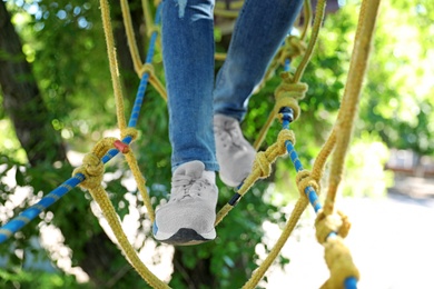 Photo of Child climbing in adventure park, closeup. Summer camp