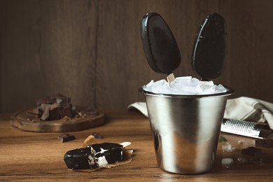 Photo of Glazed ice cream bars served in bucket on wooden table. Space for text