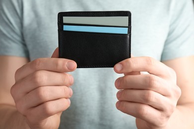 Photo of Man holding leather business card holder with cards, closeup