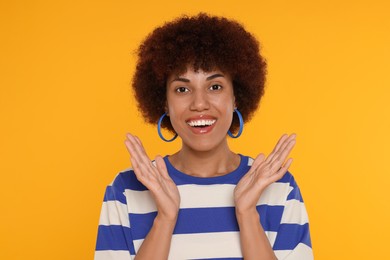 Photo of Portrait of happy young woman on orange background