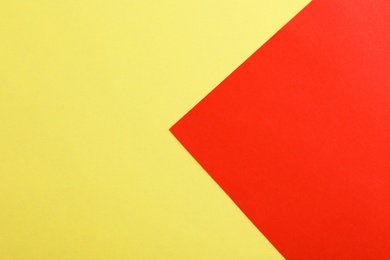 Photo of Yellow and red paper sheets as colorful background, top view