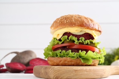 Photo of Delicious vegetarian burger on white table, space for text