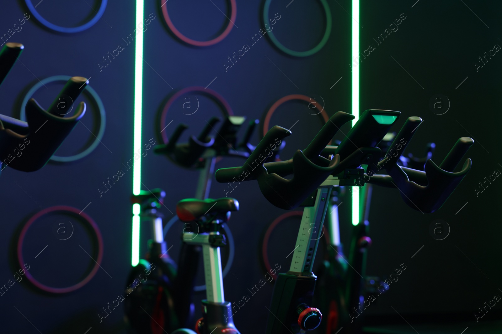 Photo of Many exercise bikes in fitness club. Indoor cycling class