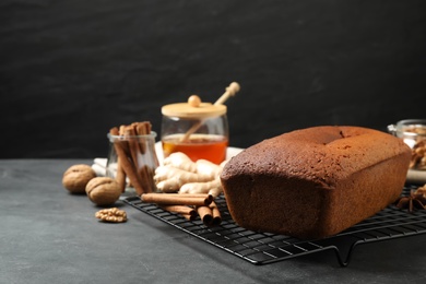Photo of Delicious gingerbread cake and ingredients on black table, space for text