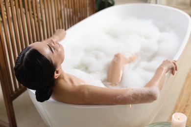 Photo of Beautiful young woman taking bubble bath at home