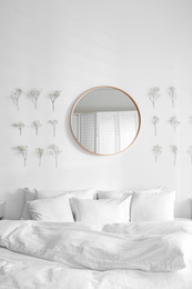 Photo of Modern bedroom interior with stylish round mirror