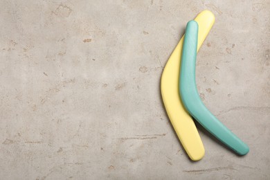 Photo of Boomerangs on light grey stone background, flat lay. Space for text