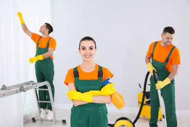 Photo of Team of professional janitors cleaning room after renovation