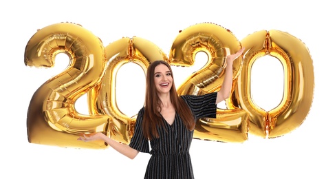Photo of Happy young woman near golden 2020 balloons on white background. New Year celebration