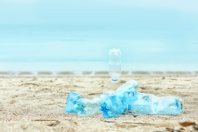 Photo of Used plastic bottles on beach, space for text. Recycling problem