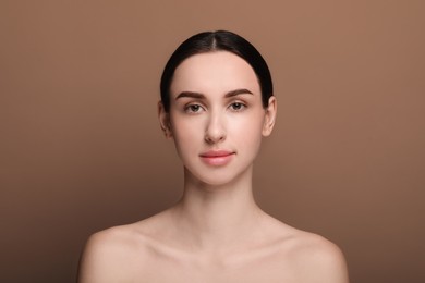 Photo of Portrait of beautiful young woman on brown background