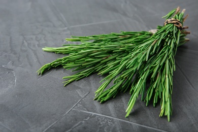 Photo of Bundle of fresh rosemary on grey background