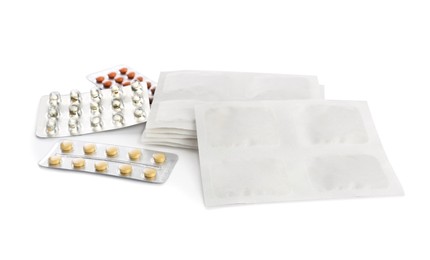 Photo of Mustard plasters and pills on white background