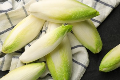 Photo of Fresh raw Belgian endives (chicory) on black table, top view