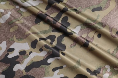 Photo of Texture of crumpled camouflage fabric as background, top view