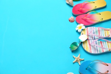 Photo of Composition with different flip flops and space for text on blue background, above view. Summer beach accessories