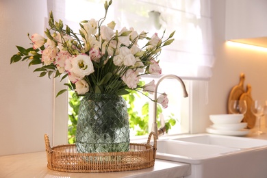 Photo of Bouquet of beautiful flowers on countertop in kitchen, space for text. Interior design