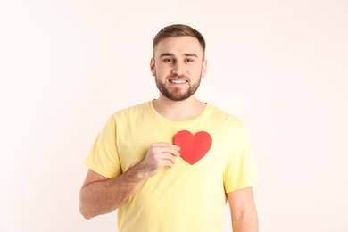 Photo of Young man with paper heart on white background