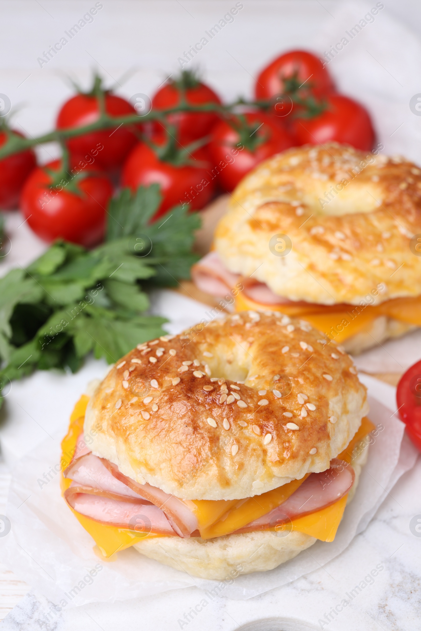 Delicious bagels with ham and cheese on white table Photo of Delicious bagels with ham and cheese on white table