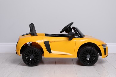 Photo of Child's electric toy car near light wall indoors