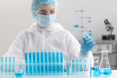 Photo of Scientist holding test tube with sample in laboratory