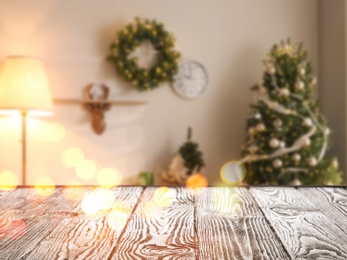 Image of Empty wooden surface and blurred view of room decorated for Christmas, space for text. Interior design