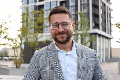 Photo of Portrait of handsome bearded man in glasses outdoors