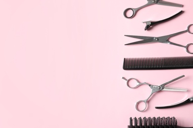 Photo of Scissors and other hairdresser's accessories on pink background, flat lay. Space for text