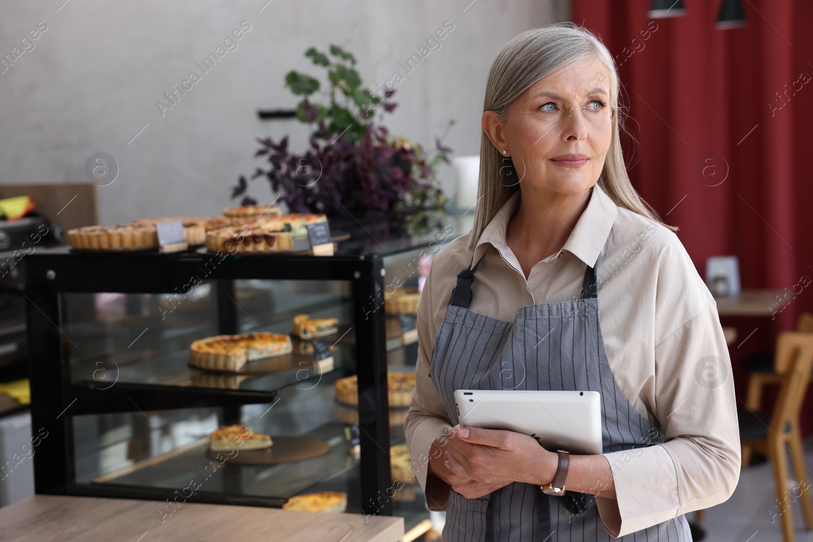 Photo of Business owner with tablet in her cafe, space for text