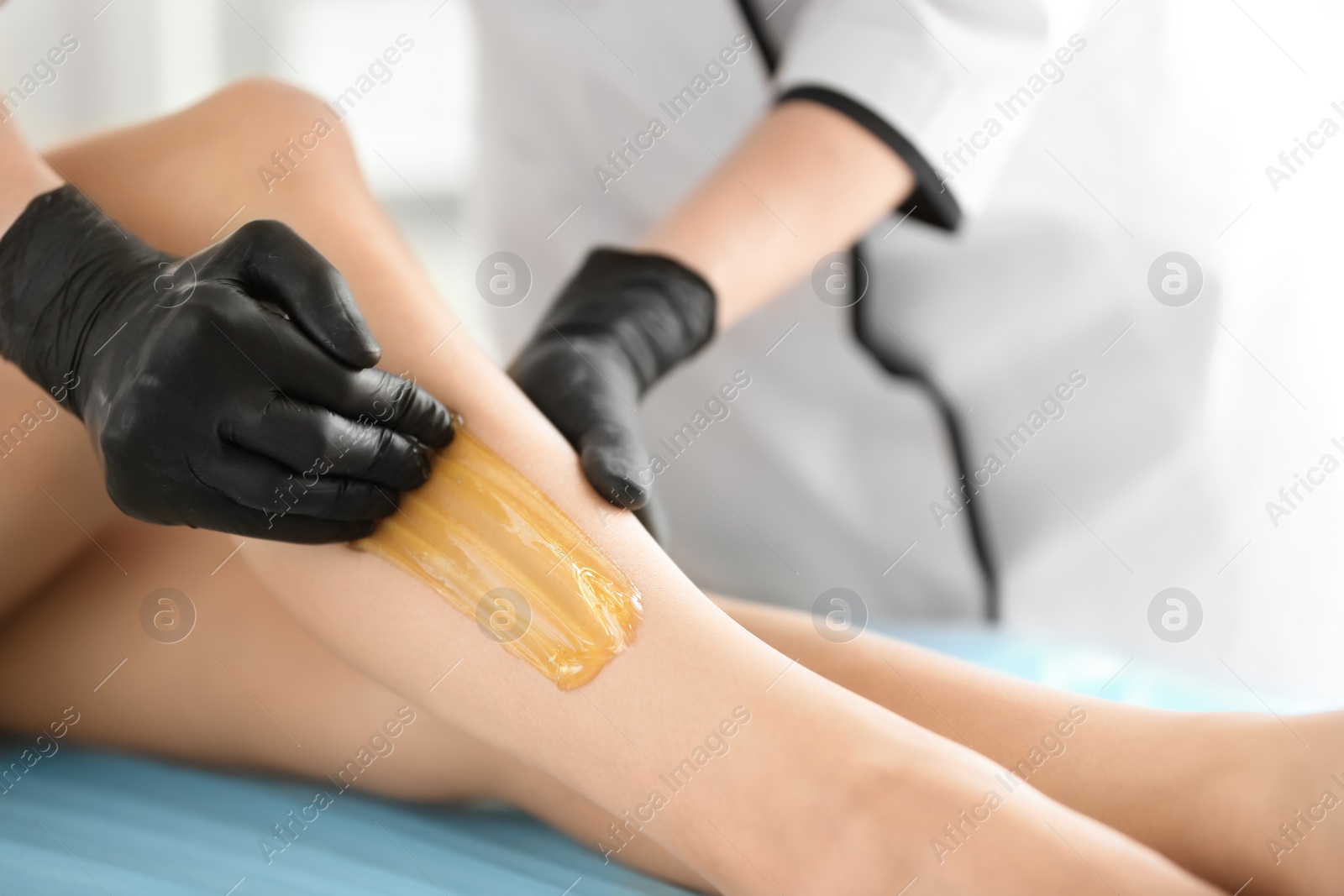 Photo of Woman getting wax epilation in salon