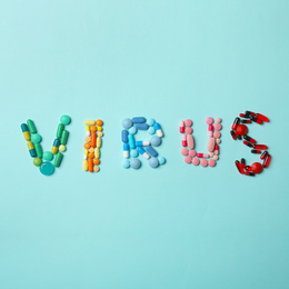 Photo of Word VIRUS made of pills on light blue background, top view