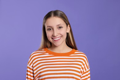 Photo of Portrait of beautiful teenage girl on purple background