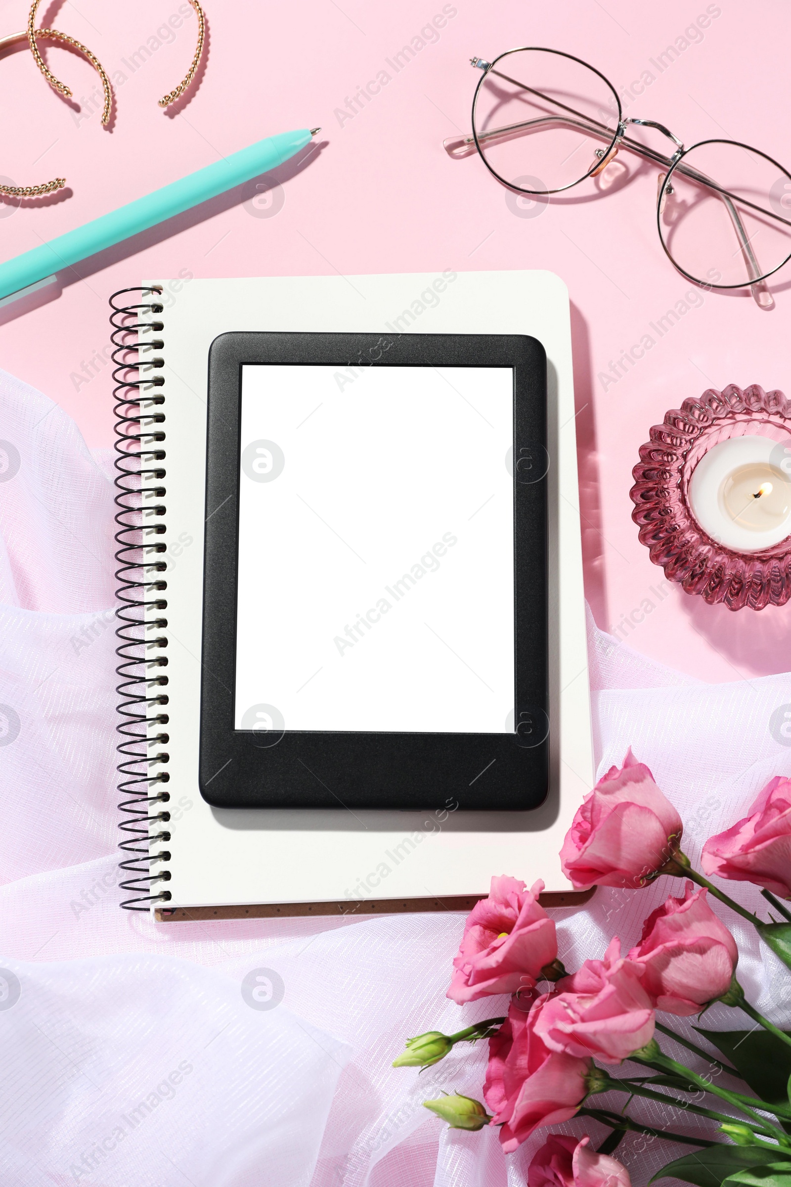 Photo of Flat lay composition with e-book reader, notebook and glasses on pink background. Space for text