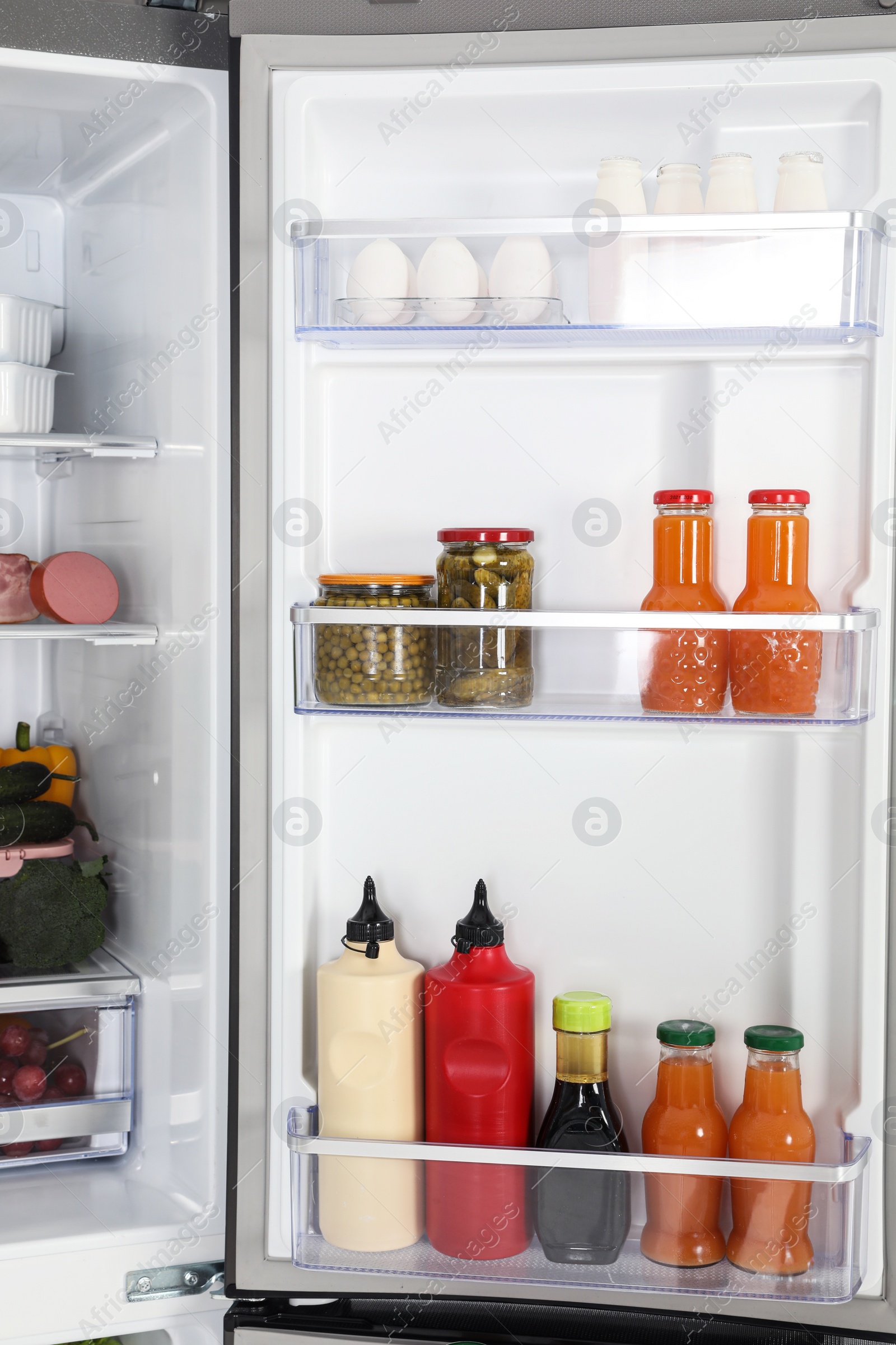 Photo of Open refrigerator full of different fresh products