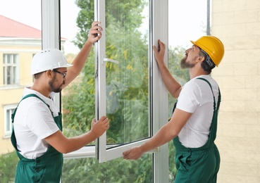 Construction workers installing new window in house