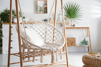 Photo of Comfortable hammock chair in stylish room. Interior design