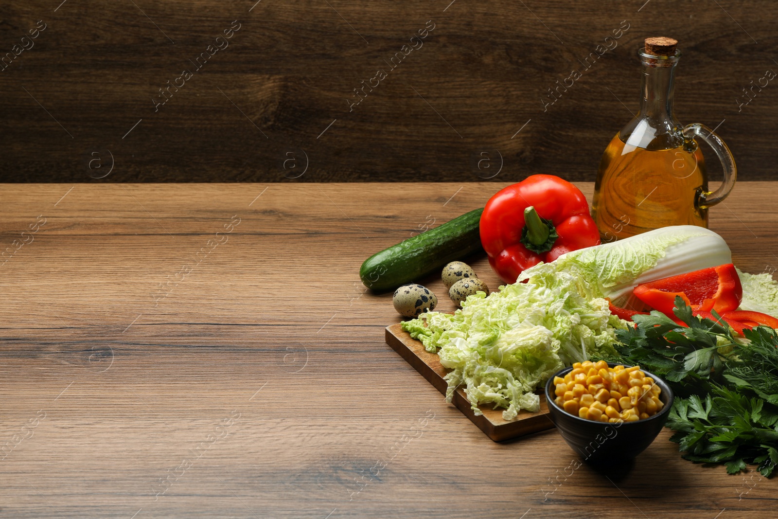 Photo of Chinese cabbage and different products on wooden table, space for text