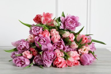 Beautiful bouquet of colorful tulip flowers on wooden table