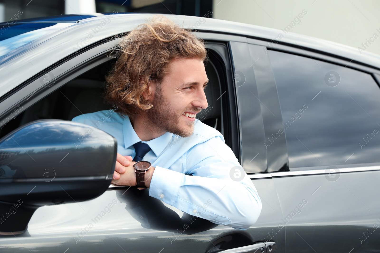 Photo of Attractive young man in his luxury car