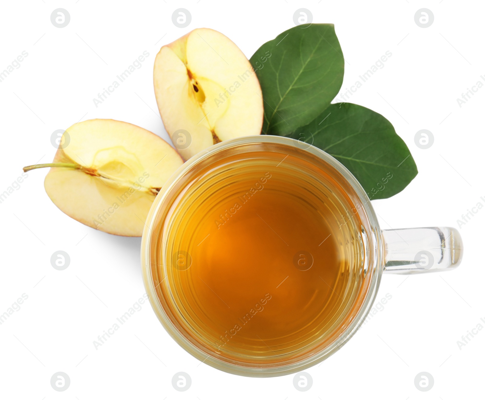Photo of Glass mug with delicious cider, pieces of ripe apple and leaves on white background, top view