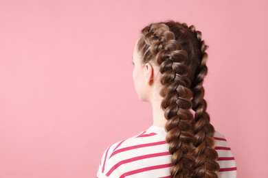 Woman with braided hair on pink background