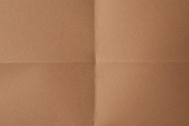 Folded kraft paper sheet as background, top view