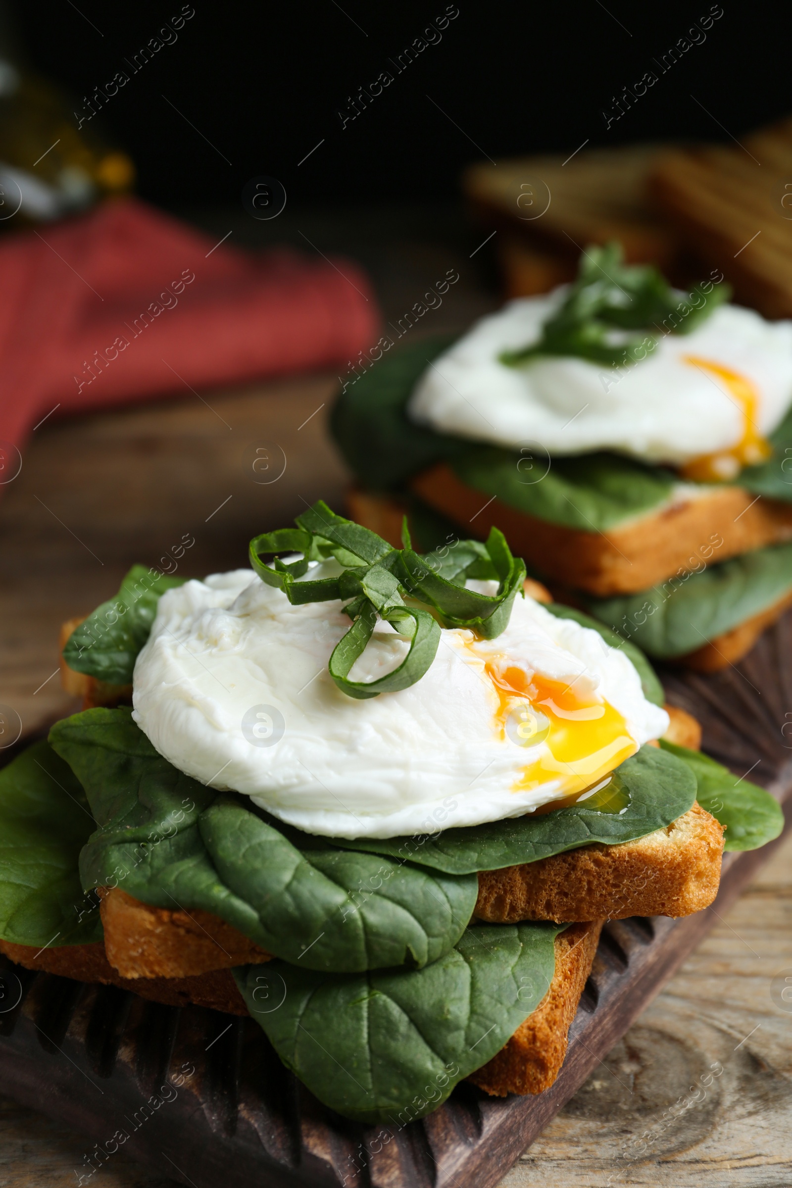 Photo of Delicious poached egg sandwiches served on wooden board