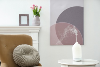 Photo of Aroma oil diffuser on white table indoors, space for text. Interior design