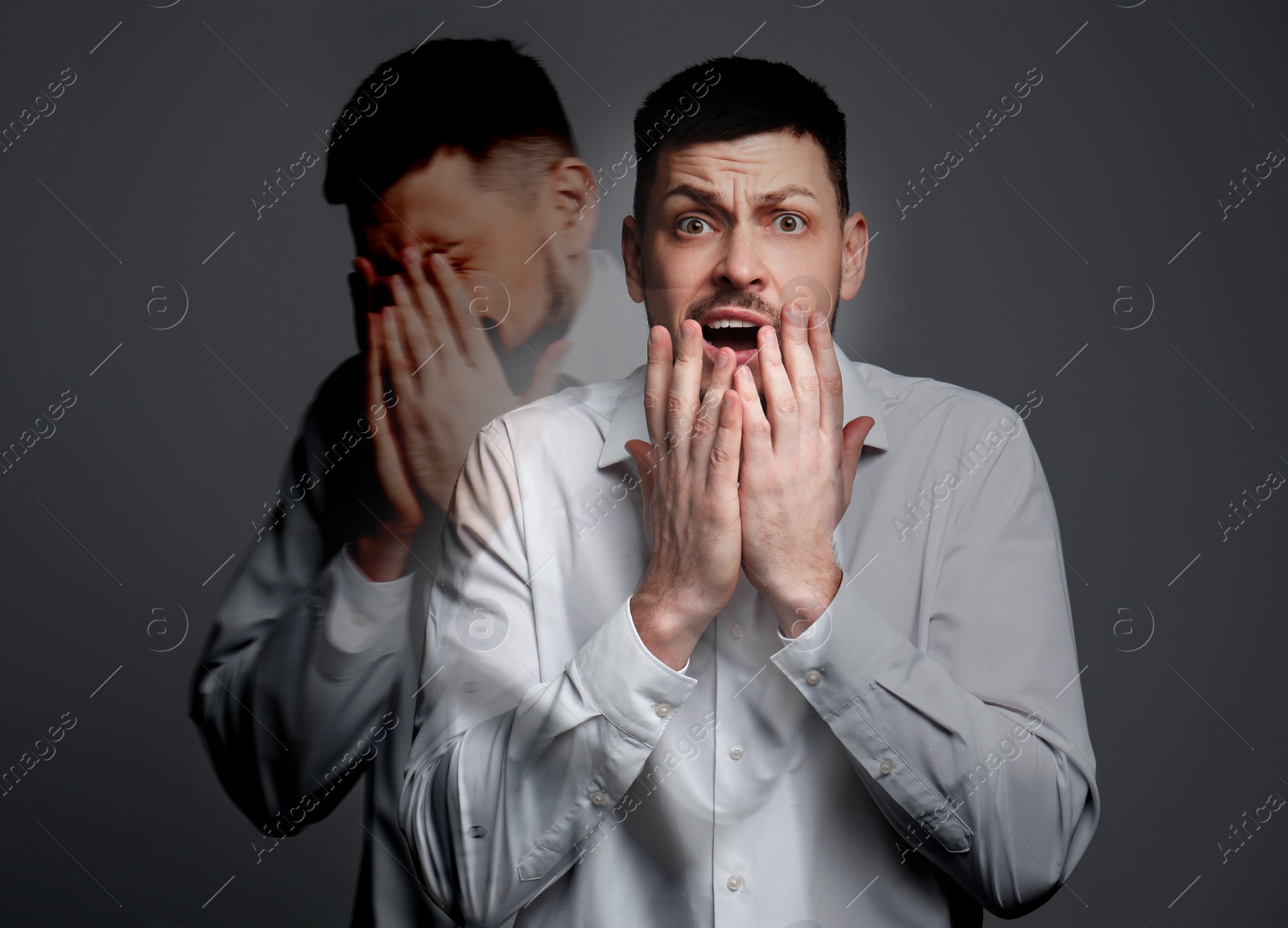 Image of Paranoia. Double exposure with photos of emotional man on dark grey background