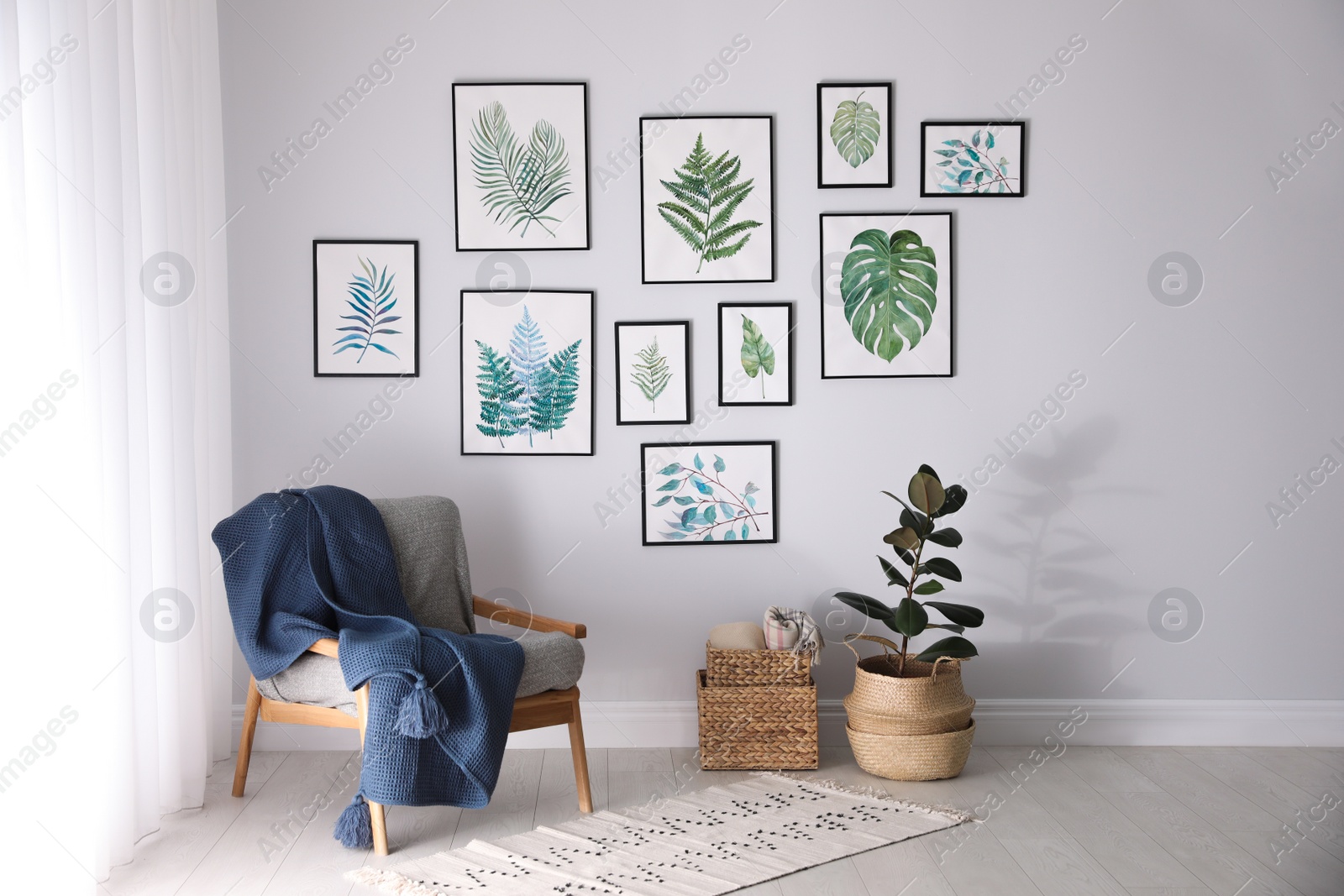 Photo of Beautiful paintings of tropical leaves on white wall in living room interior