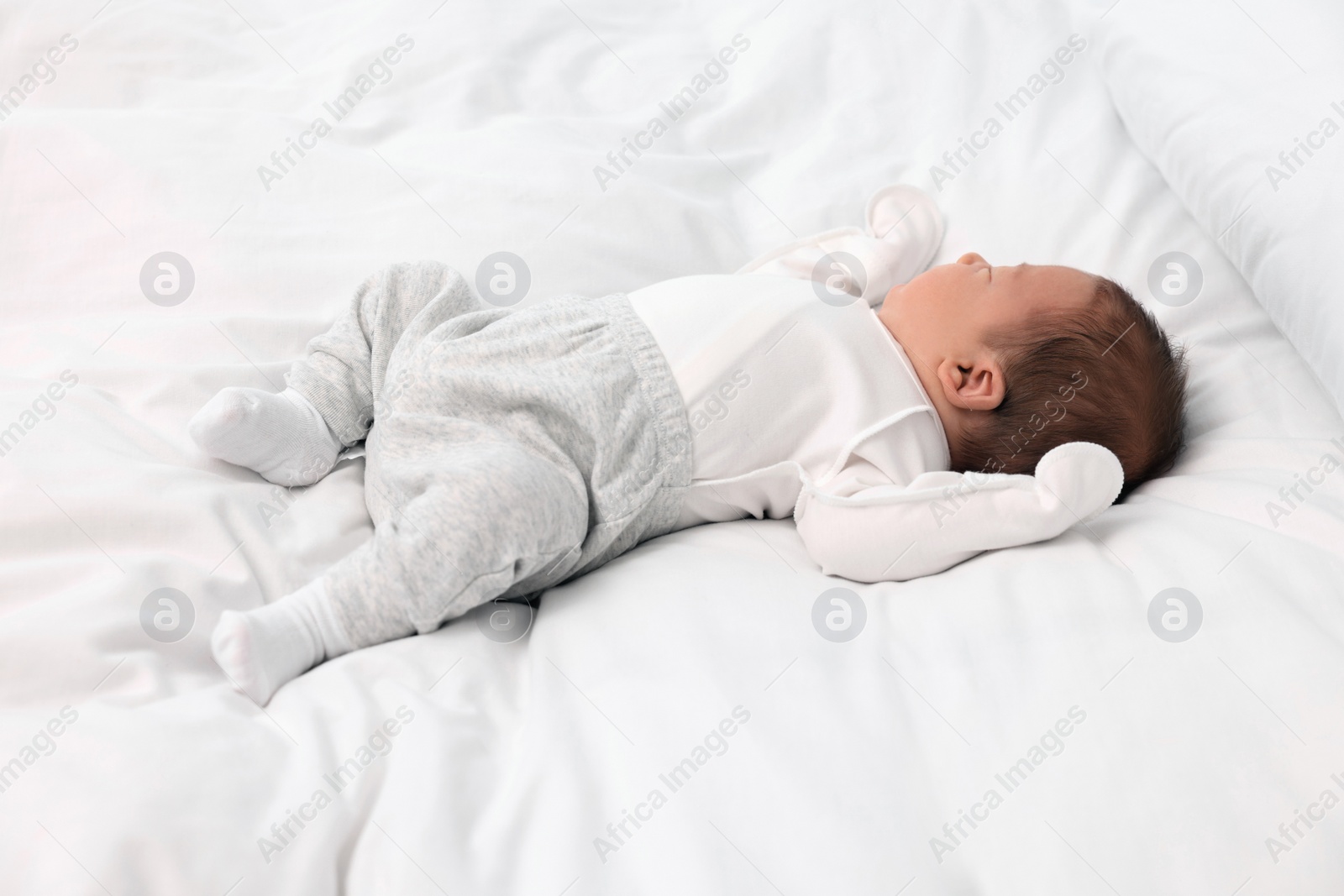 Photo of Cute newborn baby sleeping on white soft bed