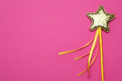 Photo of Beautiful golden magic wand on magenta background, top view. Space for text